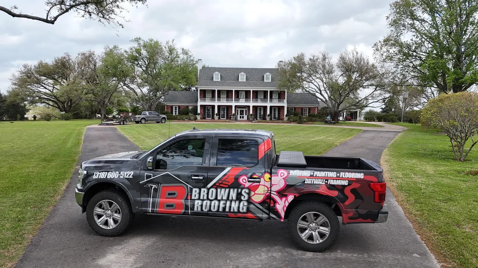 Brown's Roofing branded pickup truck parked in front of a residential home