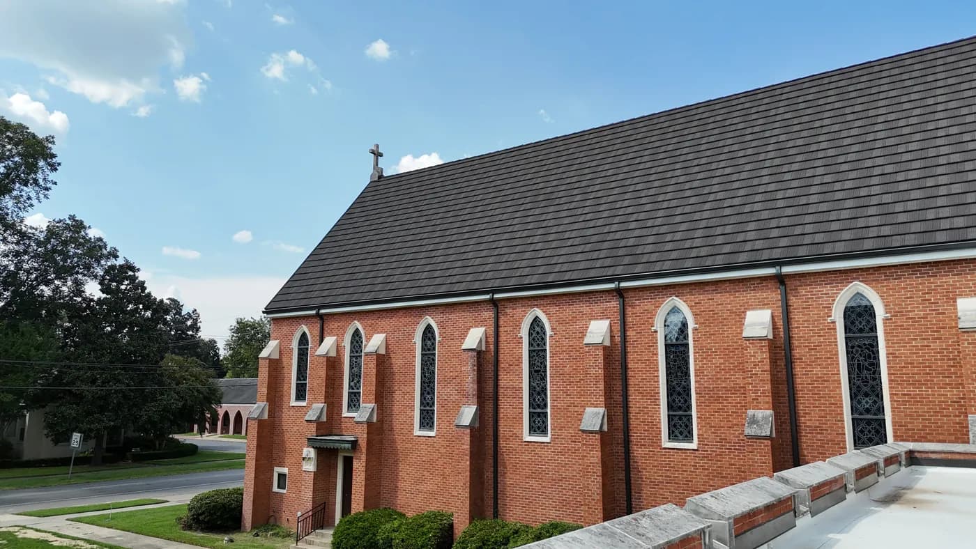 Brick gothic-style church with a new stone-coated steel shake-profile roof, viewed from the side