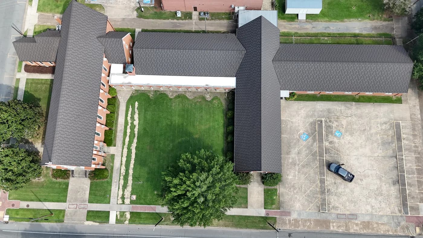 Aerial view of a stone-coated steel roof across a multi-wing brick building