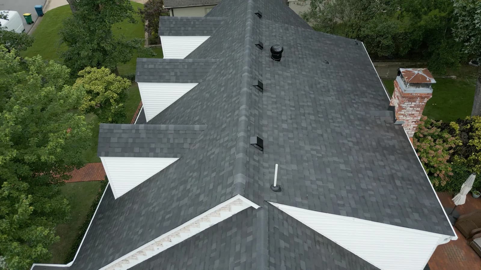 Aerial view of a Bryant, Arkansas suburban home with a multi-gable architectural shingle roof
