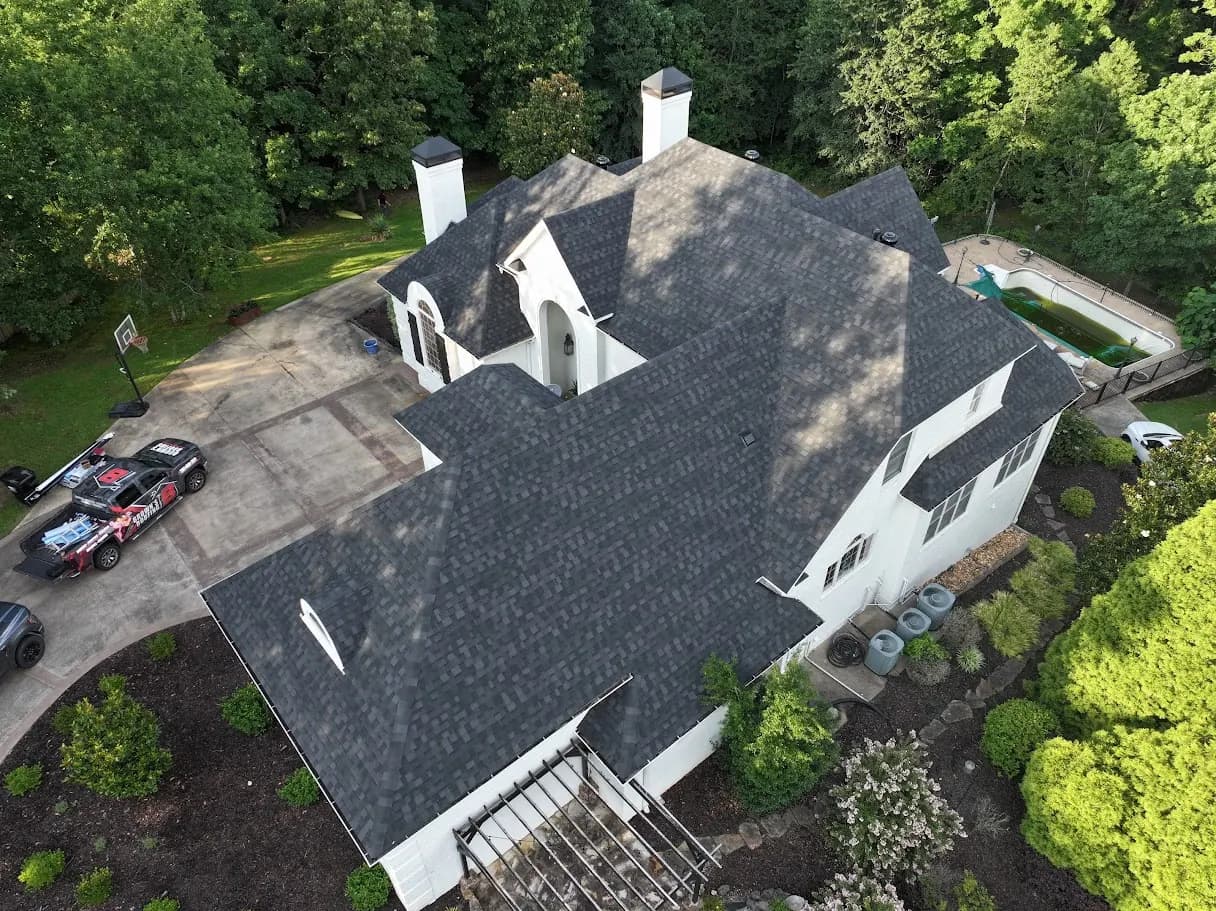 Drone aerial of a home reroof with a Brown's Roofing branded pickup in the driveway