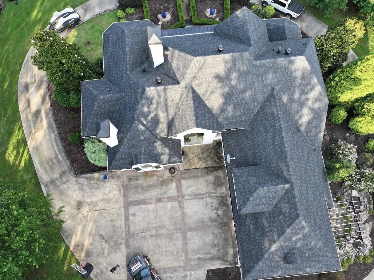 Aerial overhead of a large home with multiple hip lines and a new gray architectural shingle roof