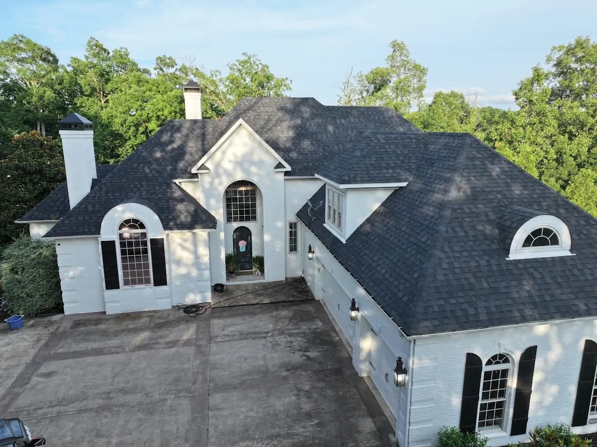 Two-story luxury home with new dark architectural shingle roof and arched windows