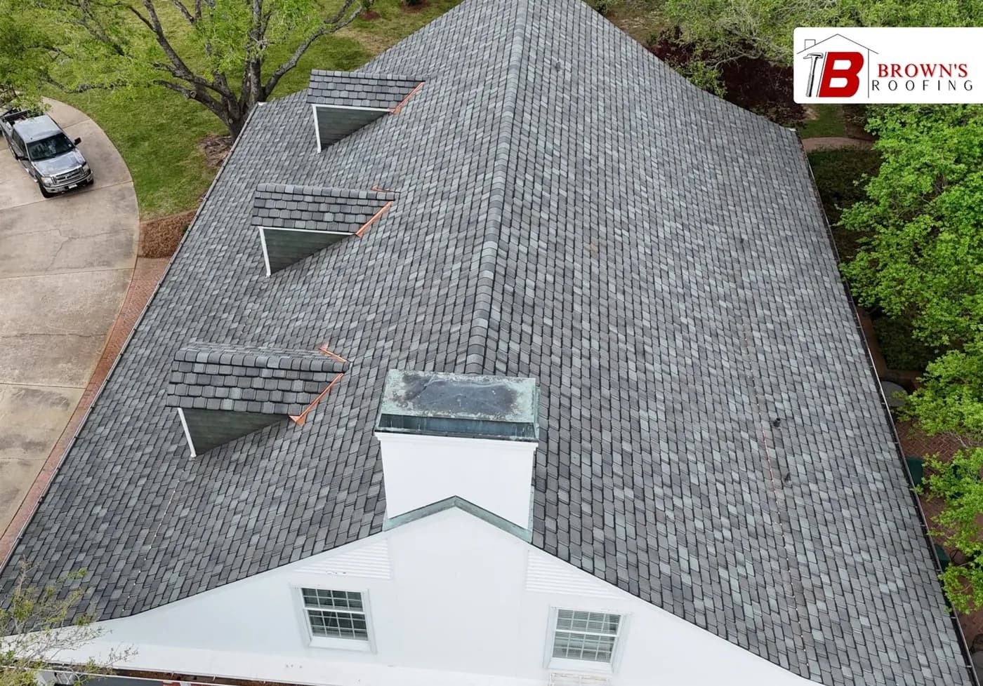 Drone close-up of a synthetic slate roof with copper dormer flashings