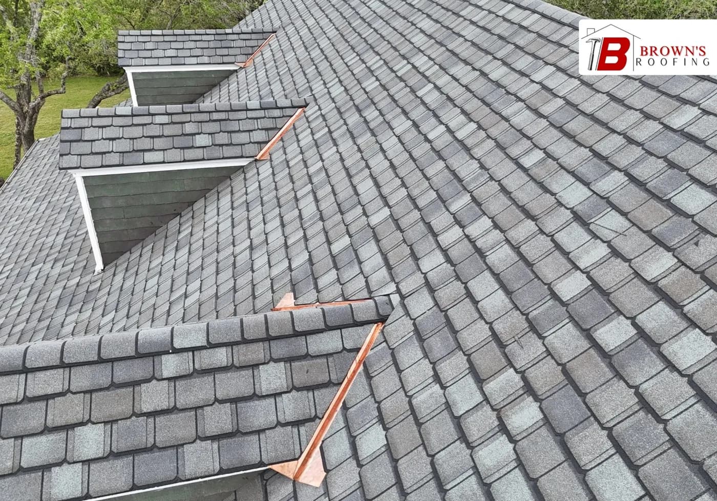 Close-up of synthetic slate roof valleys with bright copper valley flashing