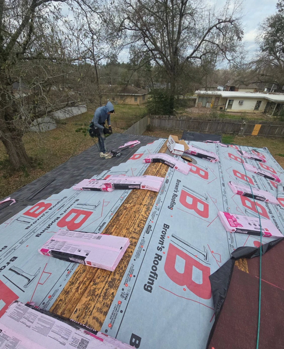 Brown's Roofing crew installing architectural shingles over synthetic underlayment on a Central Arkansas home