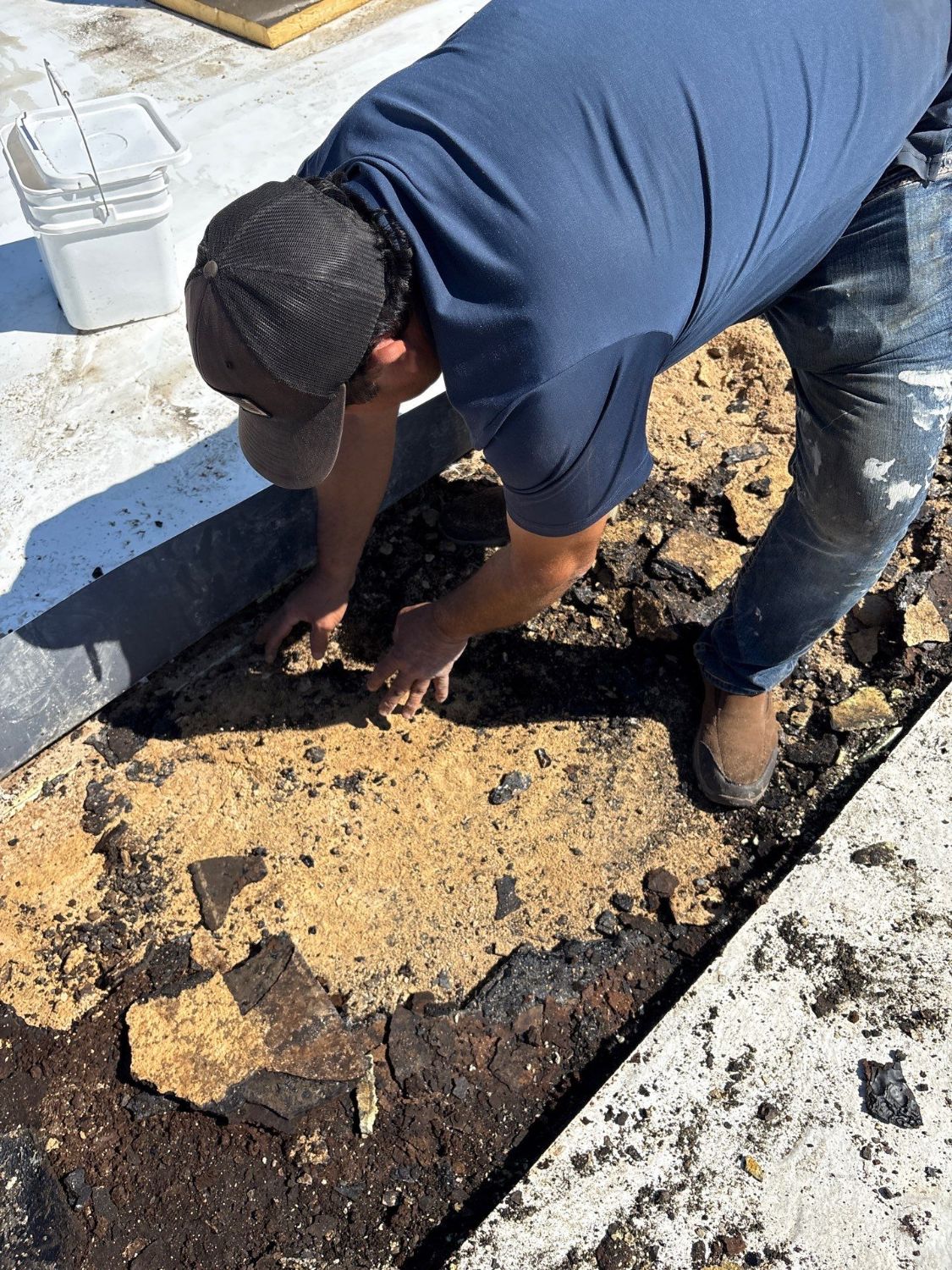 Commercial roof investigation in Monroe revealing saturated material beneath an old overlay during a core sample