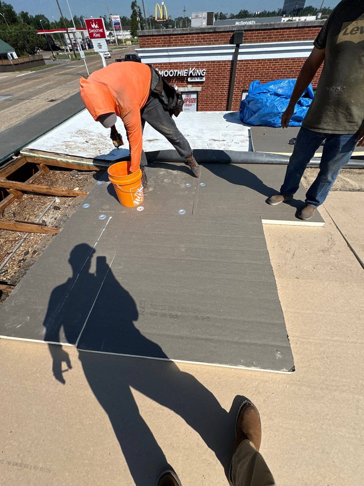 Brown's Roofing crew installing adhered GAF TPO membrane and cover board on the Monroe commercial roof