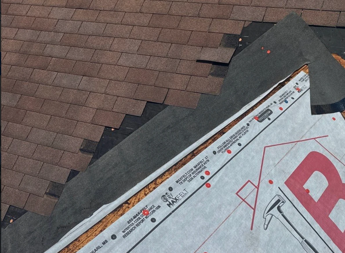 Brown asphalt shingle courses meeting a hip transition with modified bitumen membrane and synthetic underlayment on a church roof replacement in Lake Providence, Louisiana