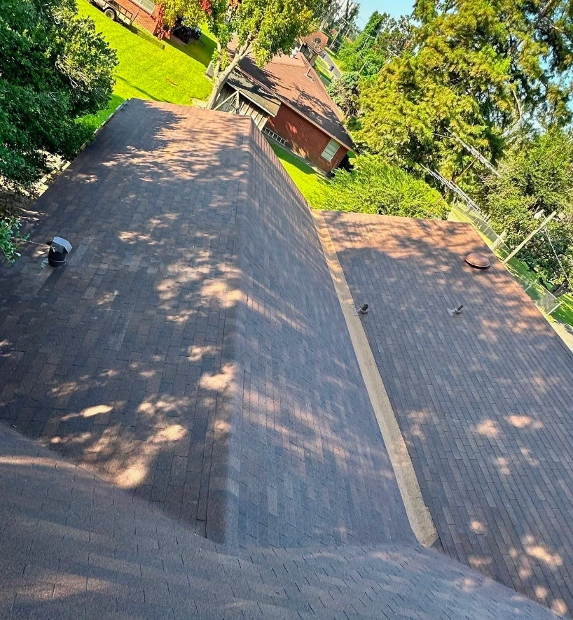 Overhead view of a church roof showing several shingle planes, a ridge, and vents meeting at multiple angles