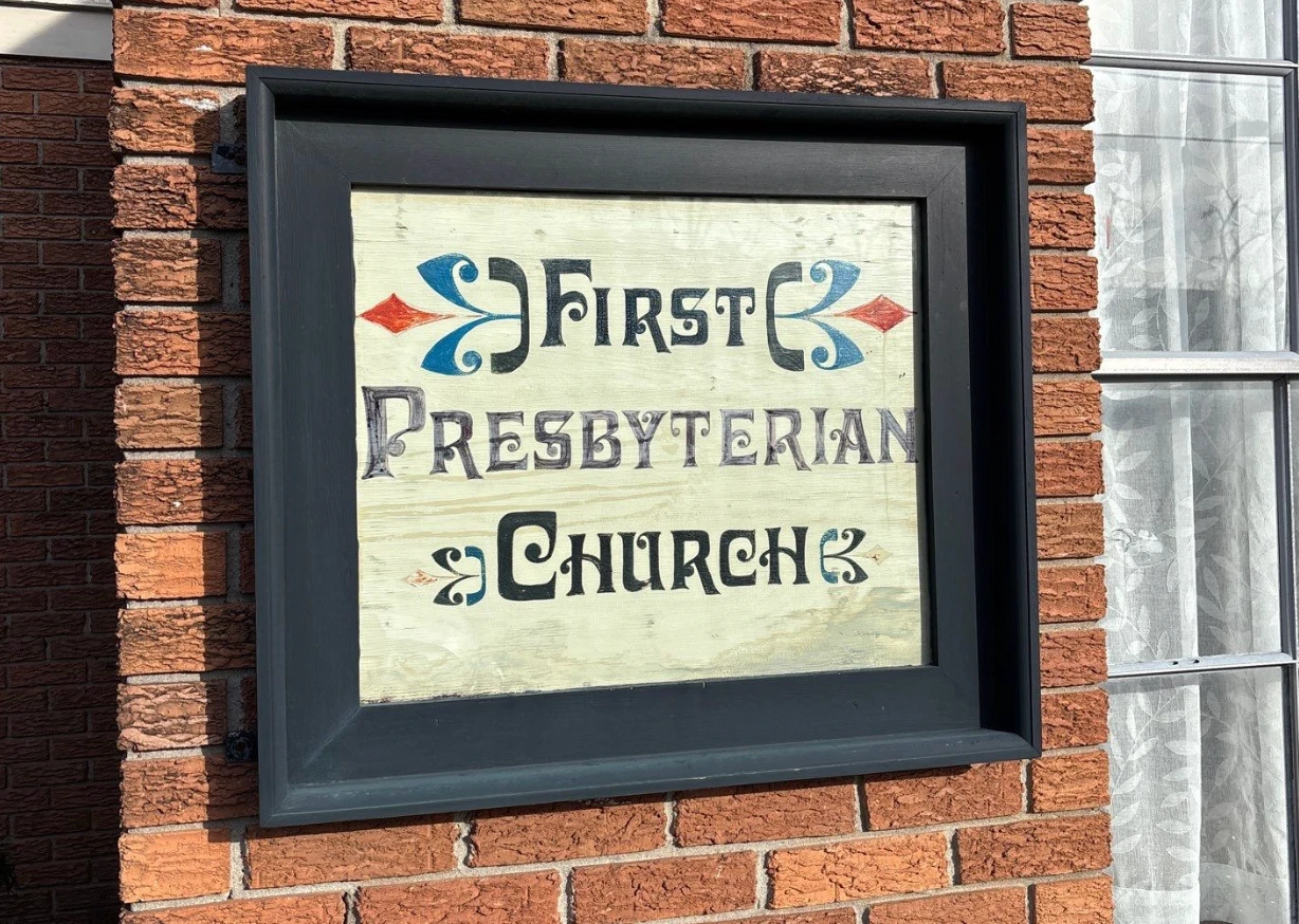 Hand-painted First Presbyterian Church sign mounted on the brick exterior of the building in Lake Providence, Louisiana
