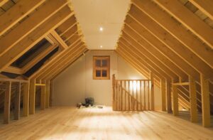 View of an attic space with exposed beams and finished floor